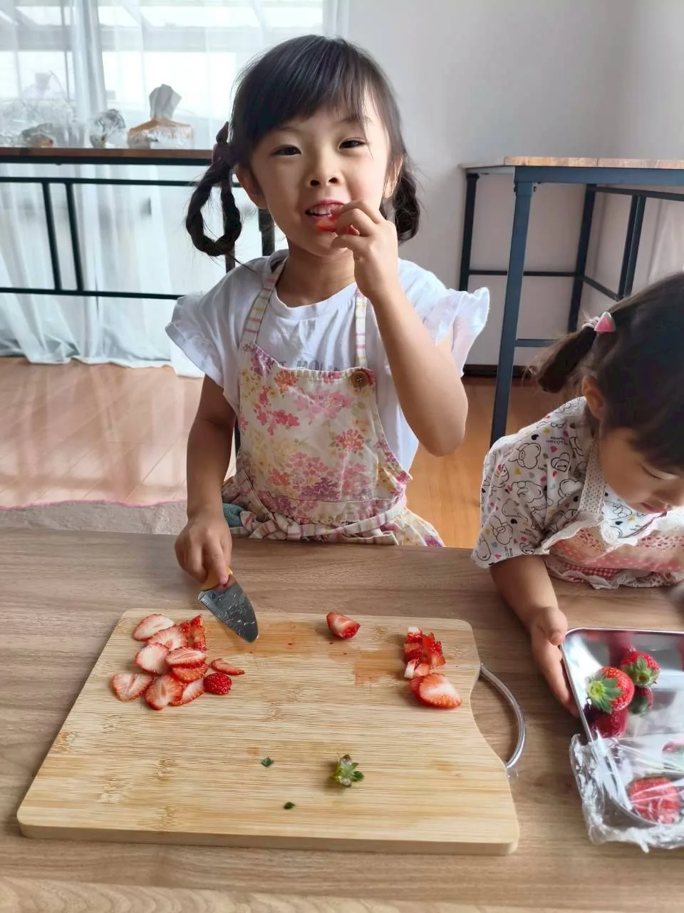 いちごを切りながらおやつ作りを楽しむ子どもの様子