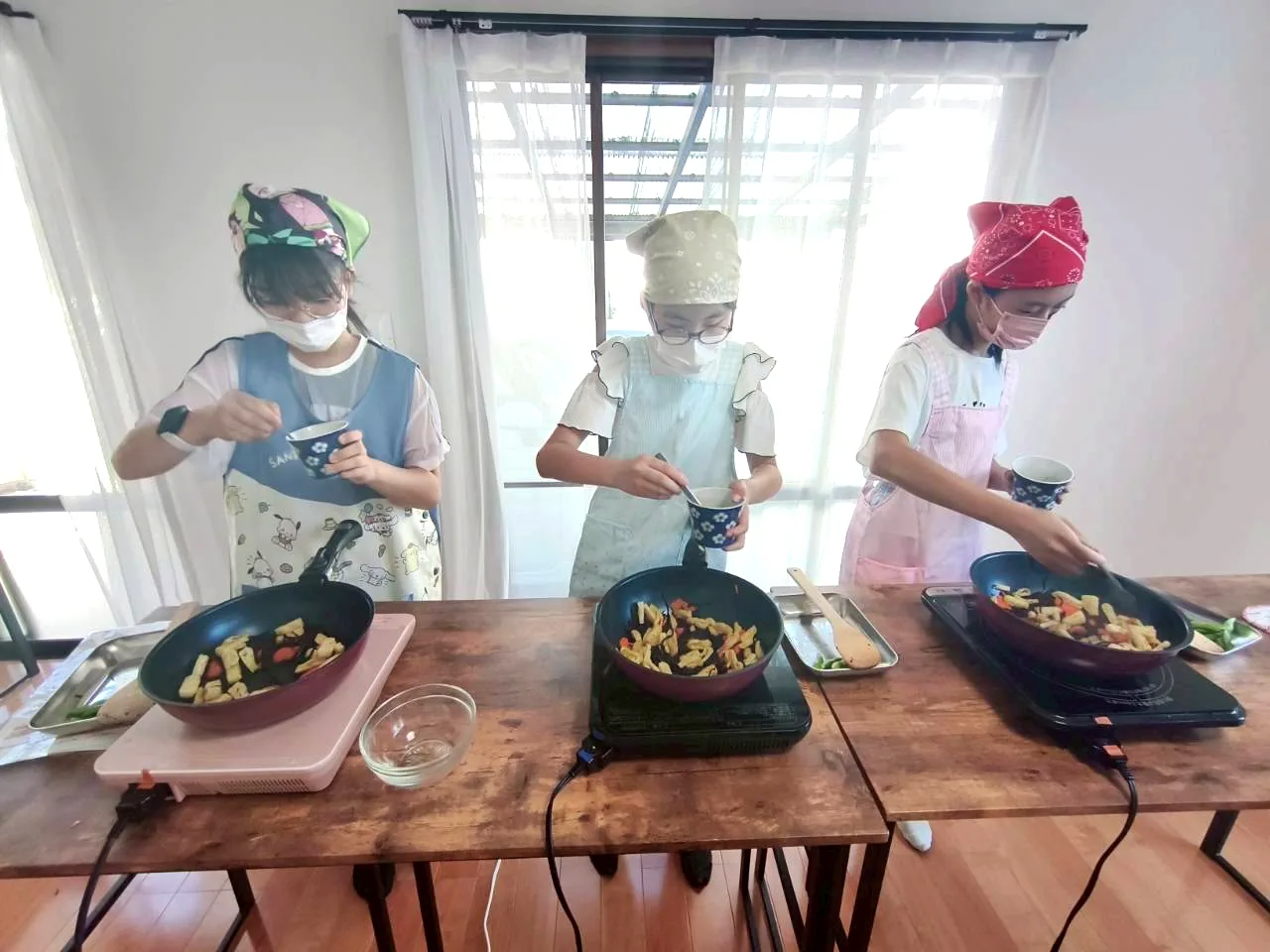 それぞれの調理台で料理をする小学生